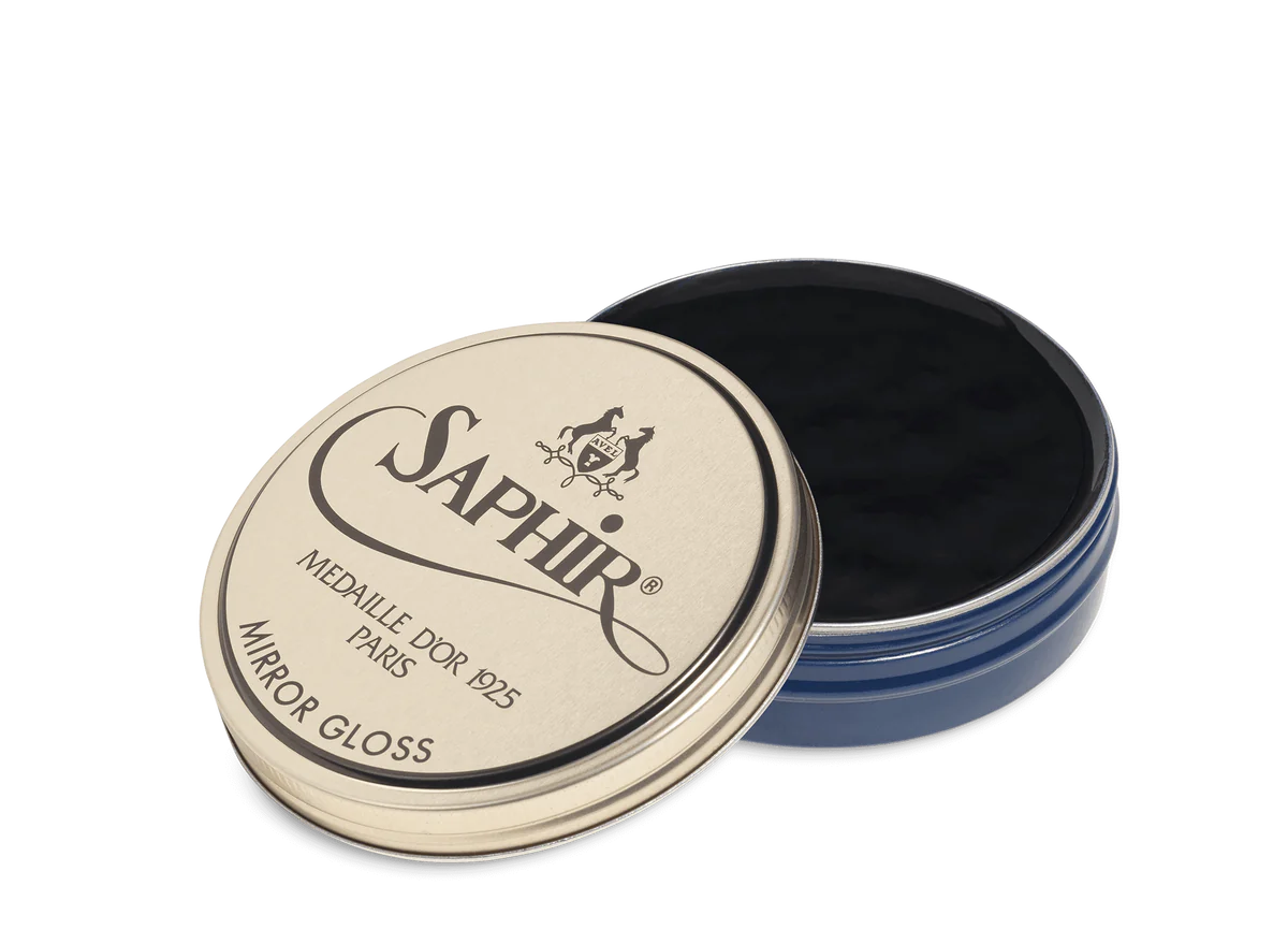 A tin of Saphir Medaille D'Or Mirror Gloss Wax Polish with the brand's logo and product name displayed on the lid.