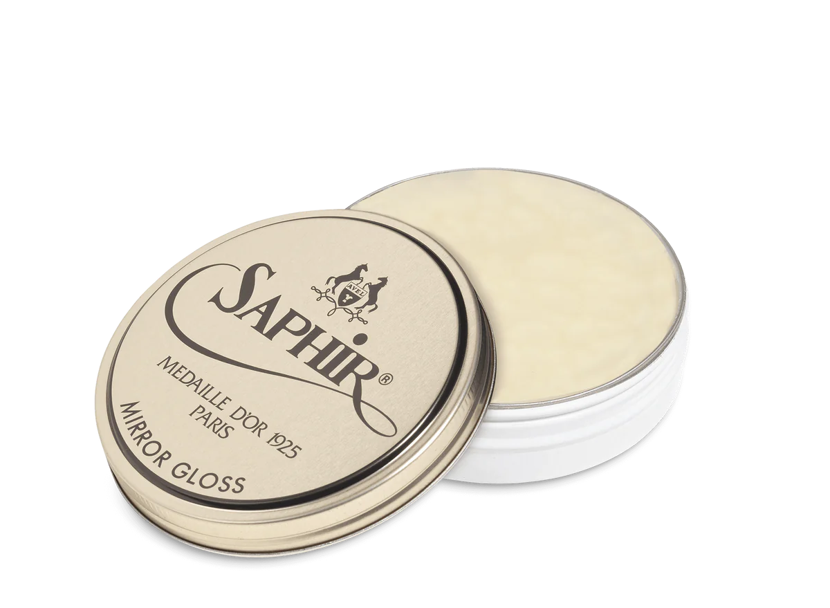 A tin of Saphir Medaille D'Or Mirror Gloss Wax Polish with the brand's logo and product name displayed on the lid.