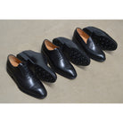 A black calf leather Berwick 1707 Oxford, Wholecut & penny loafer with a Dainite rubber sole, showing a classic round toe shape and the iconic penny slot detail.