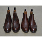 A dark brown grain leather Chelsea boot with a black elastic side panel and a round toe. The boot has a low heel and a goodyear welted dainite rubber sole.