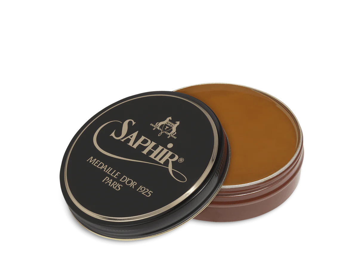 A round tin container of Saphir Medaille D'Or shoe wax polish with black lid and gold lettering.