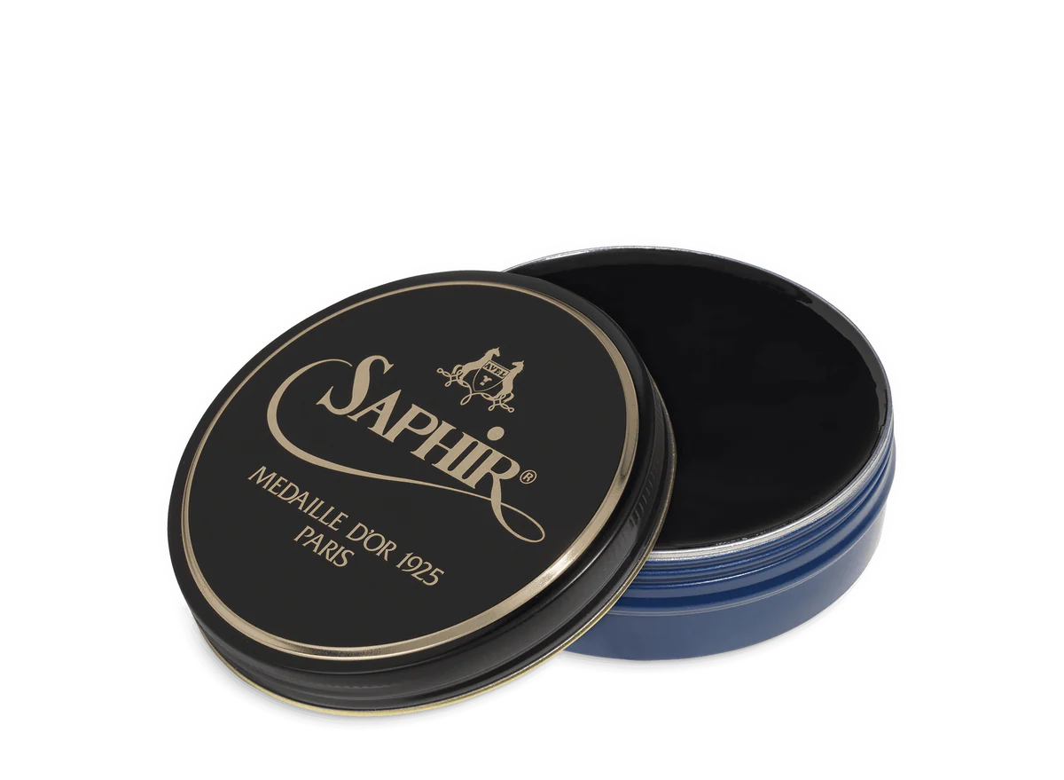 A round tin container of Saphir Medaille D'Or shoe wax polish with black lid and gold lettering.