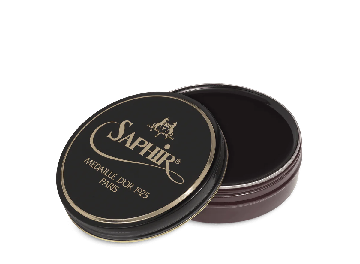 A round tin container of Saphir Medaille D'Or shoe wax polish with black lid and gold lettering.