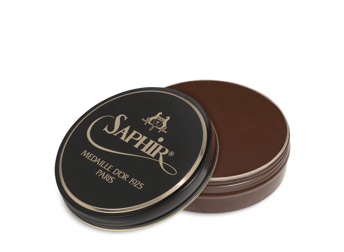 A round tin container of Saphir Medaille D'Or shoe wax polish with black lid and gold lettering.