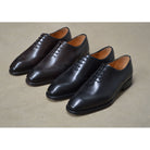 A black wholecut Oxford brogue shoe with a brogue pattern on the upper, a lace-up closure, and a goodyear welted leather sole.