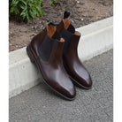 A dark brown leather Chelsea boot with a side pull tab and a low heel & Dainite soles