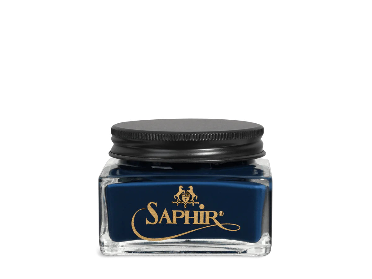 A glass jar with a black lid labeled 'SAPHIR' containing cream shoe polish.