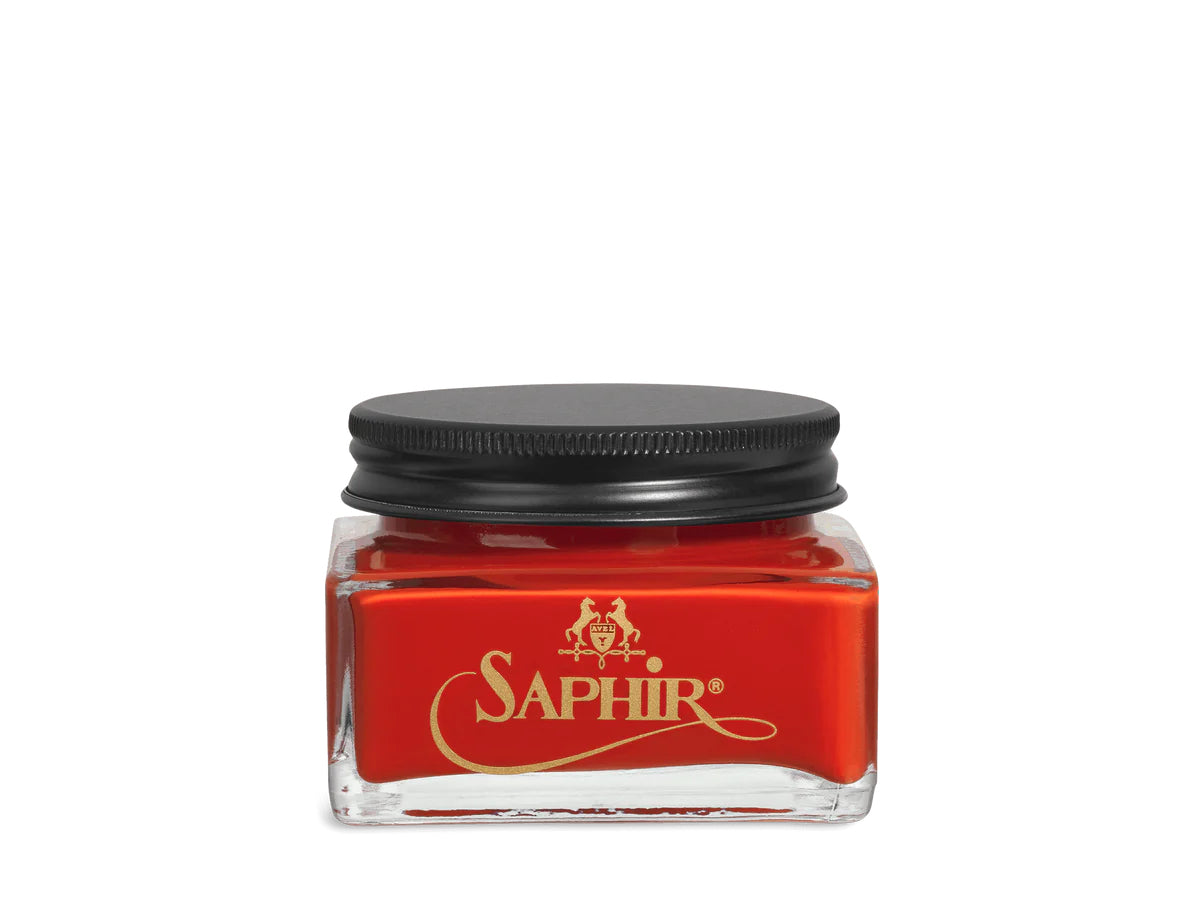 A glass jar with a black lid labeled 'SAPHIR' containing cream shoe polish.
