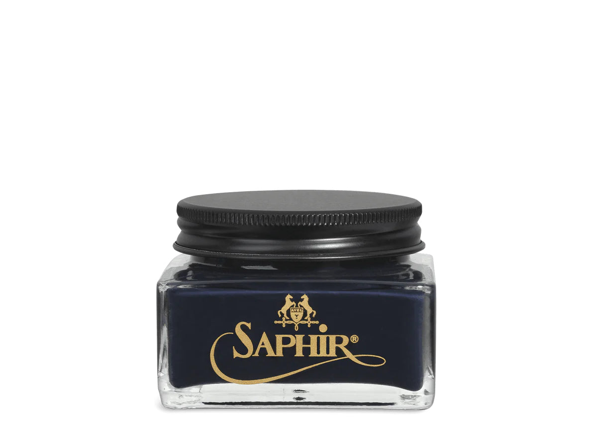 A glass jar with a black lid labeled 'SAPHIR' containing cream shoe polish.