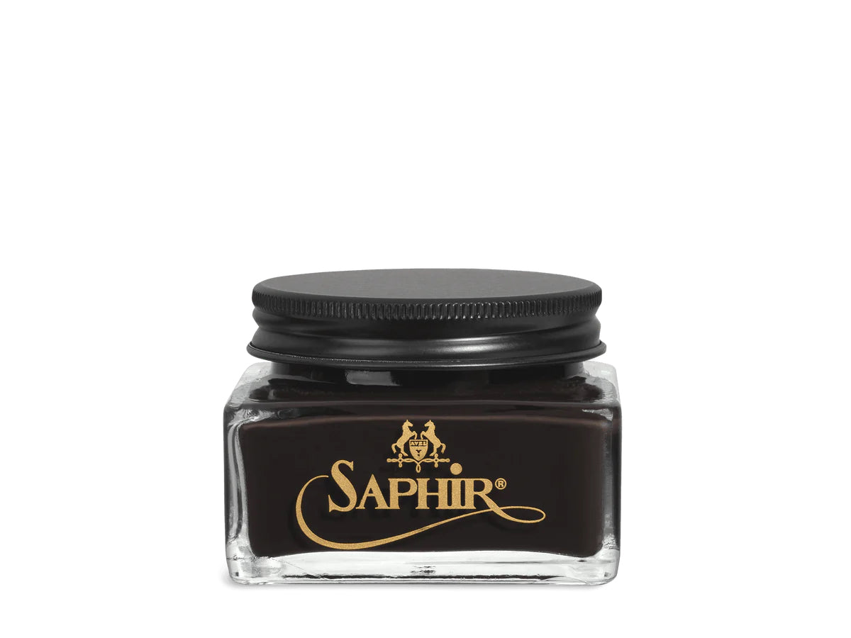 A glass jar with a black lid labeled 'SAPHIR' containing cream shoe polish.