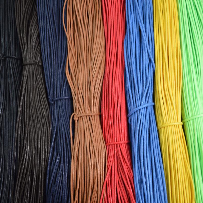 Assorted coloured waxed round casual shoe laces, tied in individual bundles.