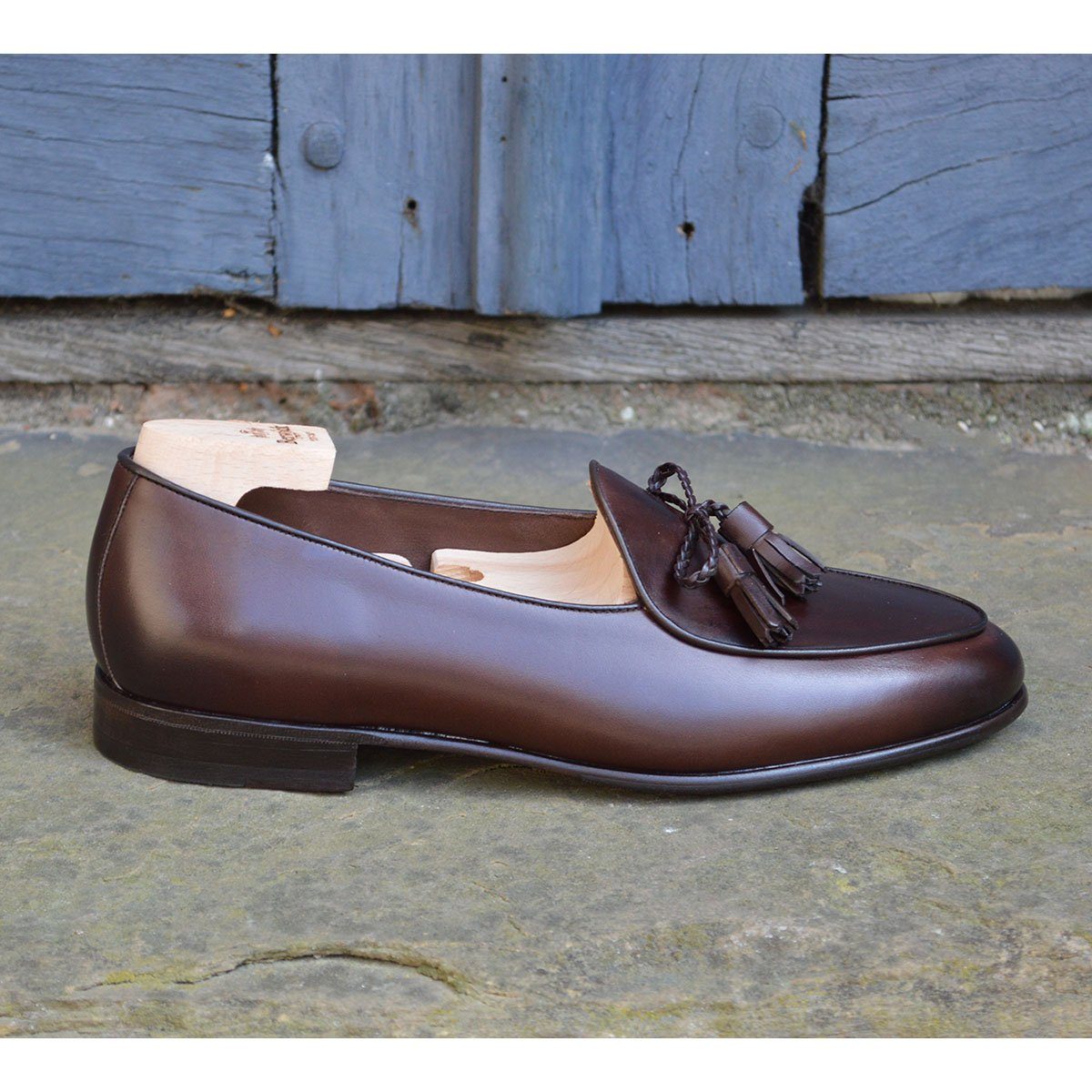 A Berwick 1 707 dark brown leather Belgian loafer with a braided leather bow tie and tassel adornment.