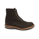 A dark brown Trickers Bernwood service boot made of Hydro Nubuck with a Dainite sole, featuring brass eyelets and a cream Barbour welt.