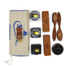 An assortment of shoe care products from Saphir Medaille D'Or including polishing cloths, brushes, cream polishes in black and medium brown, a shoe bag and a neutral wax polish.