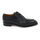 A black, boxcalf leather Oxford shoe with a chisel toe and lace-up closure, crafted in Spain.