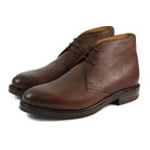 A dark brown grain leather chukka boot with a round toe and goodyear welted dainite rubber sole.
