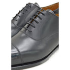 A black, boxcalf leather Oxford shoe with a chisel toe and lace-up closure, crafted in Spain.