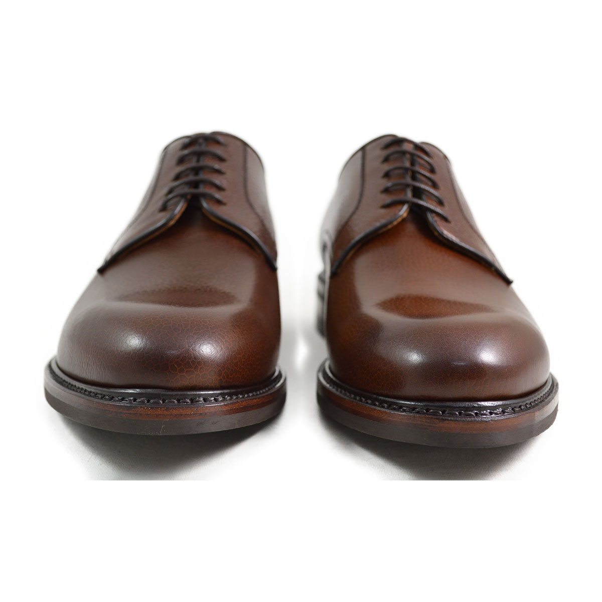 A dark brown, grainy-textured leather derby shoe with a round toe and classic lace-up closure & Dainite soles