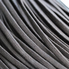 A close-up view of dark brown or black flat waxed cotton shoe laces, 3mm wide and 800mm long.