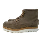 A grey and tan suede apron boot with lace-up closure, featuring a white sole and a natural welt.