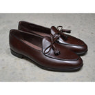 A Berwick 1 707 dark brown leather Belgian loafer with a braided leather bow tie and tassel adornment.
