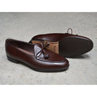 A Berwick 1 707 dark brown leather Belgian loafer with a braided leather bow tie and tassel adornment.