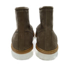 A grey and tan suede apron boot with lace-up closure, featuring a white sole and a natural welt.