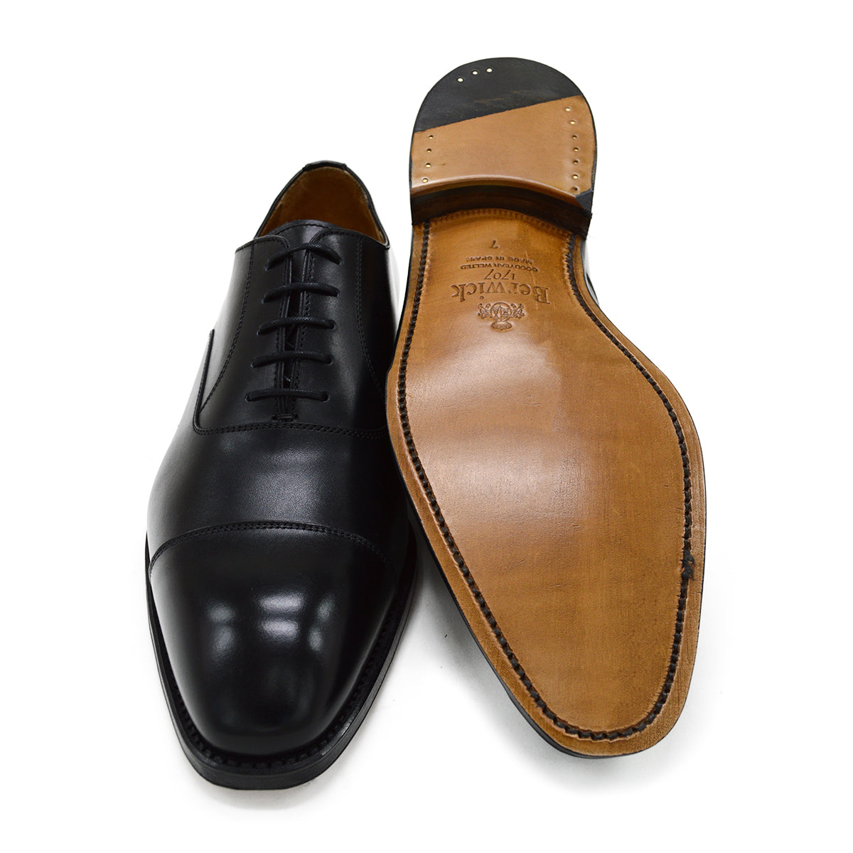 A black, boxcalf leather Oxford shoe with a chisel toe and lace-up closure, crafted in Spain.
