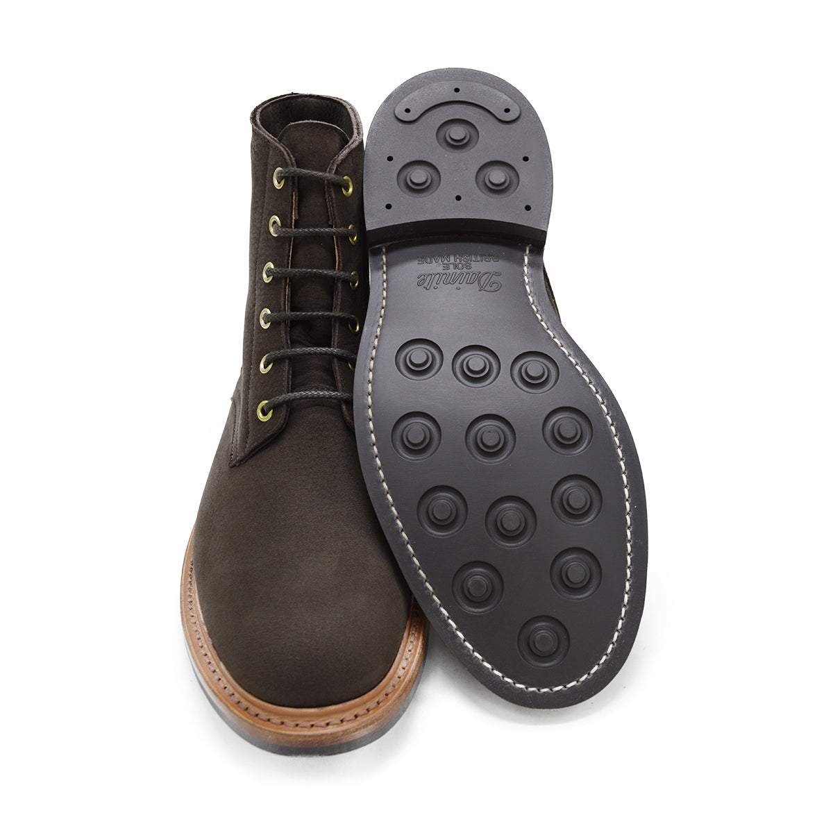 A dark brown Trickers Bernwood service boot made of Hydro Nubuck with a Dainite sole, featuring brass eyelets and a cream Barbour welt.