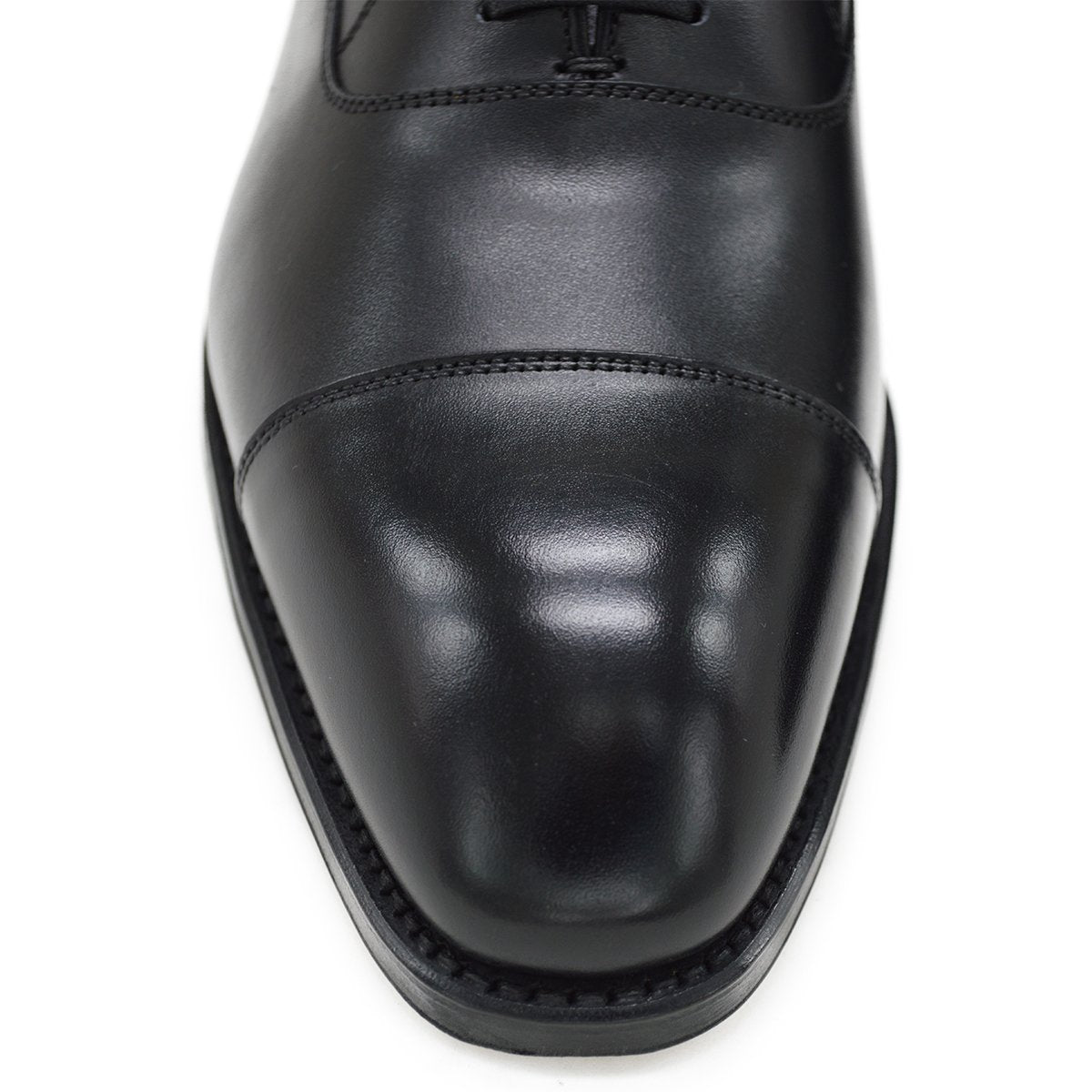 A black, boxcalf leather Oxford shoe with a chisel toe and lace-up closure, crafted in Spain.