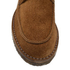A brown Berwick 1707 5432 Apron Boot with lace-up closure, handcrafted from reverse kudu suede, featuring moccasin stitching and a crepe rubber sole.