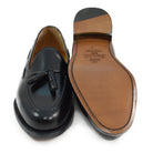 A black tasselled slip-on shoe with a high shine finish and a classic round toe.
