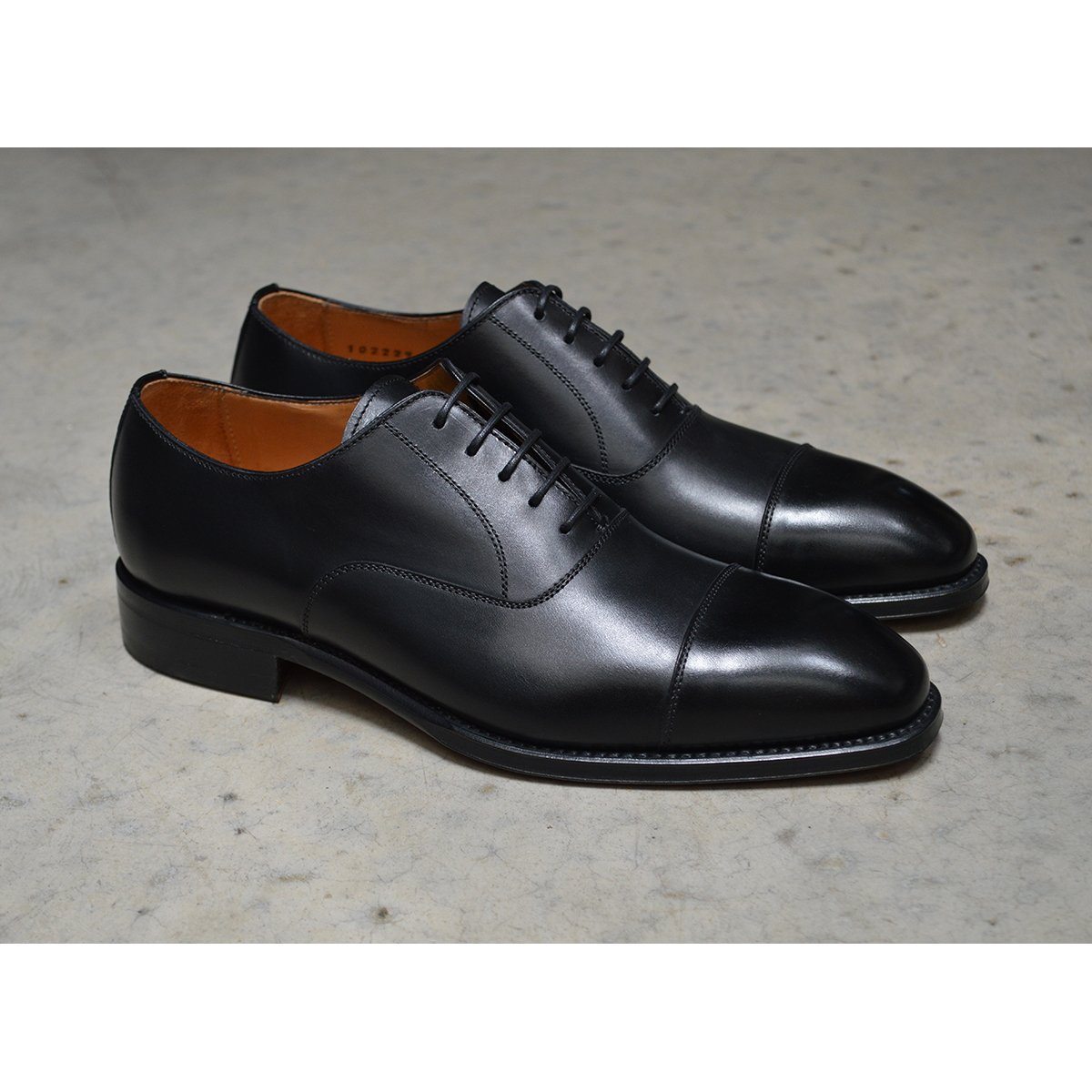 A black, boxcalf leather Oxford shoe with a chisel toe and lace-up closure, crafted in Spain.