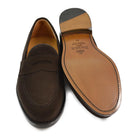 A dark brown suede penny loafer with a Goodyear welted leather sole, displayed on a white background.