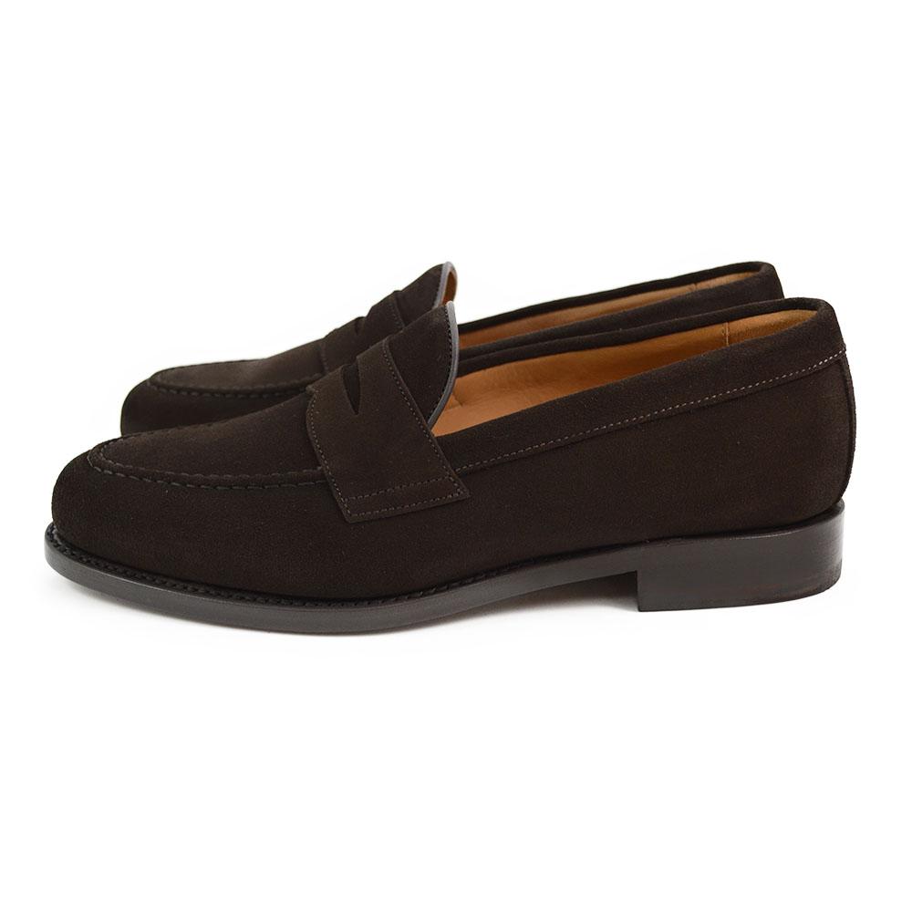 A dark brown suede penny loafer with a Goodyear welted leather sole, displayed on a white background.