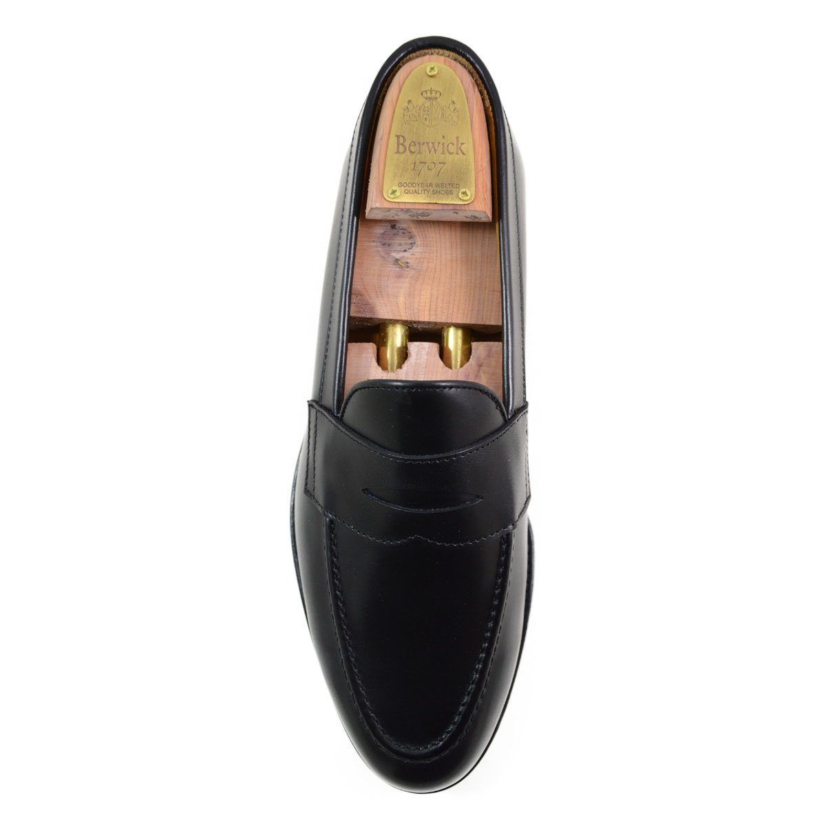 A classic black leather penny loafer shoe for men, with a closed vamp and a low heel.
