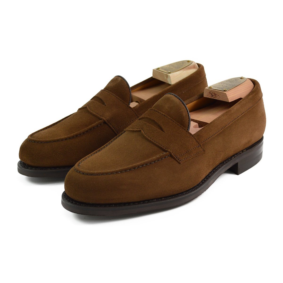 A brown suede penny loafer with a Dainite rubber sole, showing a classic round toe shape and a signature penny slot detail & Dainite Soles