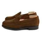 A brown suede penny loafer with a Dainite rubber sole, showing a classic round toe shape and a signature penny slot detail & Dainite Soles