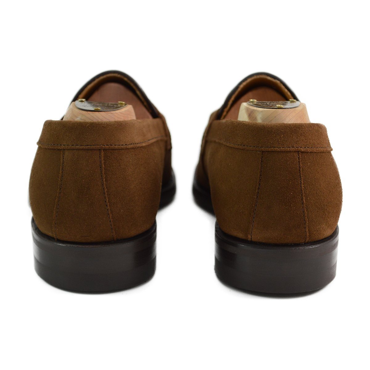 A brown suede penny loafer with a Dainite rubber sole, showing a classic round toe shape and a signature penny slot detail & Dainite Soles