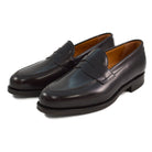 A dark brown Berwick 1707 Penny Loafer with a high-shine finish and a Dainite rubber sole.
