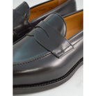 A dark brown Berwick 1707 Penny Loafer with a high-shine finish and a Dainite rubber sole.