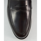A dark brown Berwick 1707 Penny Loafer with a high-shine finish and a Dainite rubber sole.