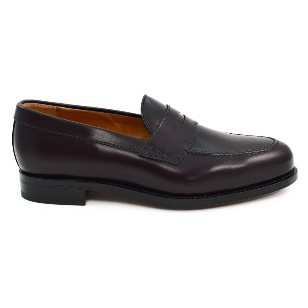 A burgundy high-shine leather penny loafer by Berwick 1707, displaying the classic round toe shape and the brand's distinctive penny slot detail.
