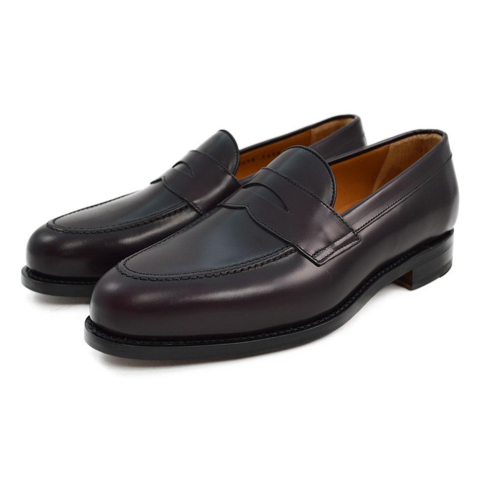 A burgundy high-shine leather penny loafer by Berwick 1707, displaying the classic round toe shape and the brand's distinctive penny slot detail.