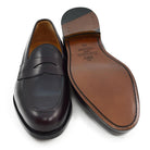 A burgundy high-shine leather penny loafer by Berwick 1707, displaying the classic round toe shape and the brand's distinctive penny slot detail.