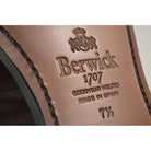A burgundy high-shine leather penny loafer by Berwick 1707, displaying the classic round toe shape and the brand's distinctive penny slot detail.