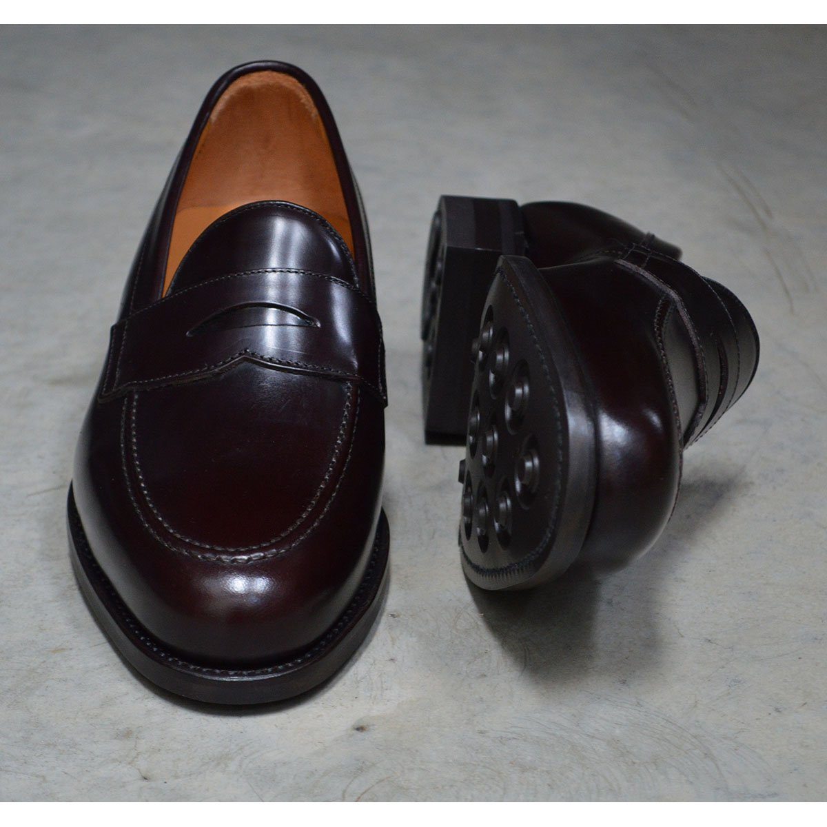 A dark brown Berwick 1707 Penny Loafer with a high-shine finish and a Dainite rubber sole.