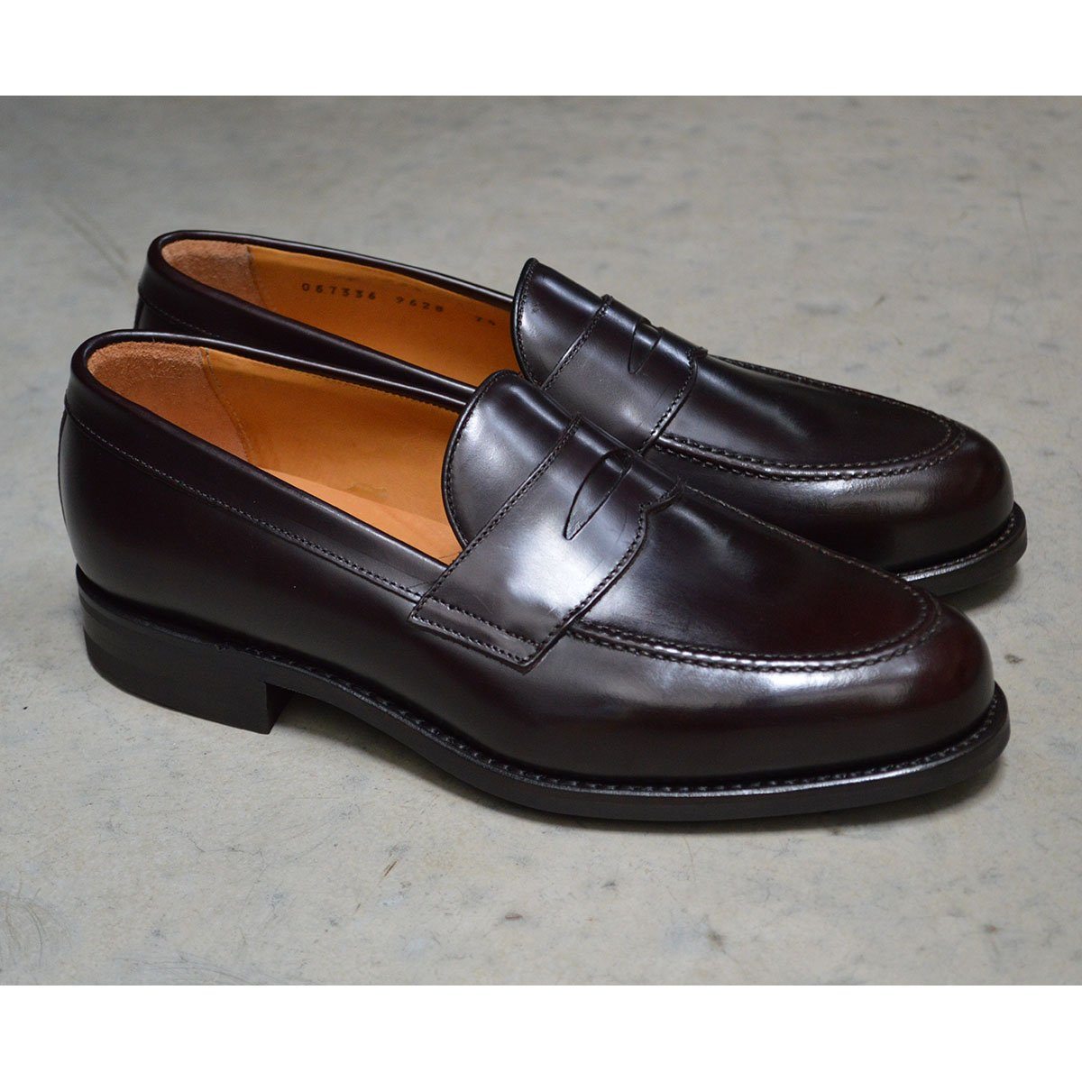 A dark brown Berwick 1707 Penny Loafer with a high-shine finish and a Dainite rubber sole.