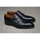 A Berwick 1707 lack double monk shoe with two buckle straps, made from calf leather and featuring a Goodyear welted leather sole.