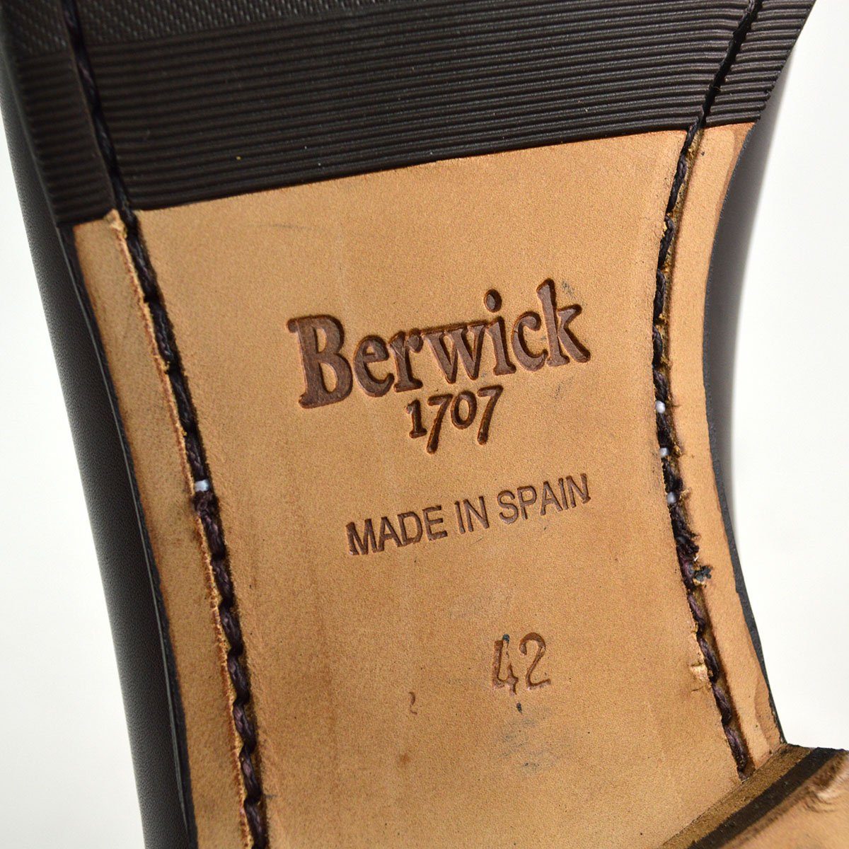 A Berwick 1 707 dark brown leather Belgian loafer with a braided leather bow tie and tassel adornment.
